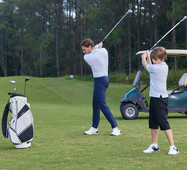 Father and son in MAELREG polos ready to swing together on the golf course.