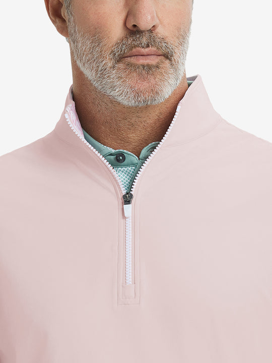 Close-up from nose to chest, showing collar detail and zipper of the light pink golf vest.