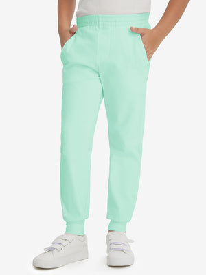 Model wearing turquoise fleece stretch water resistant boys joggers, front view showing lower body and pants.
