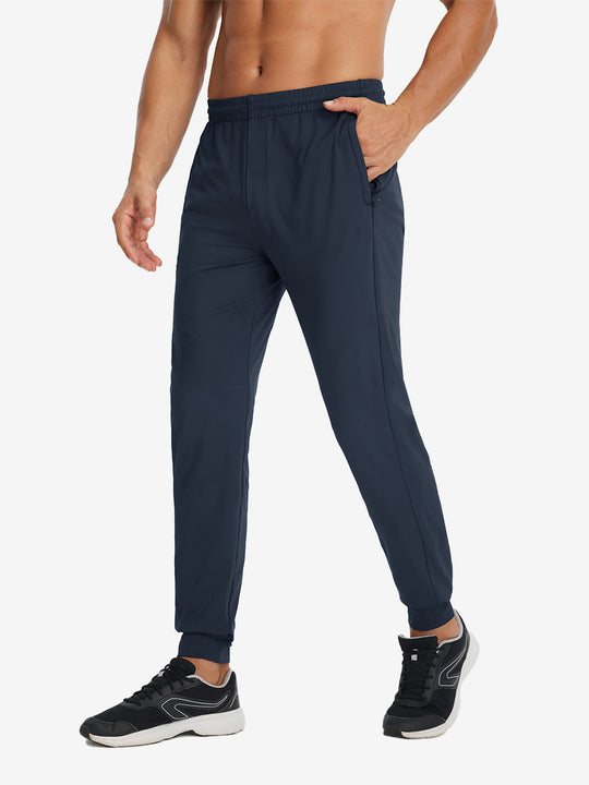 Side view of model with hand in pocket wearing lightweight traning track pants in navy.