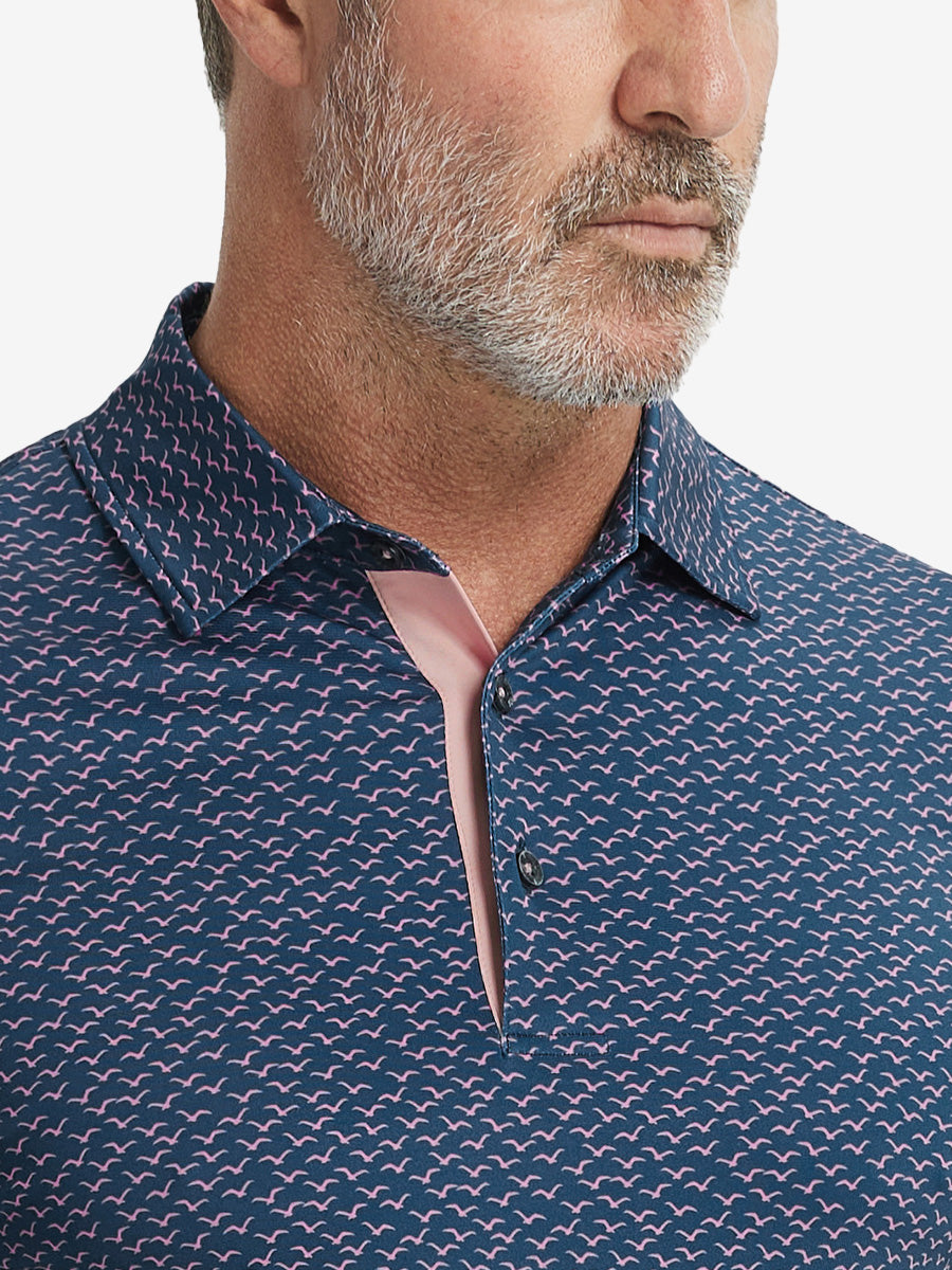 Close-up from nose to chest, showing collar and fabric pattern detail of the navy pink seagull polo shirt.