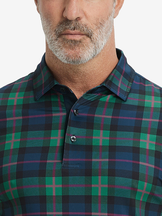 Close-up from nose to chest, showing collar and fabric pattern detail of the dark plaid polo shirt.