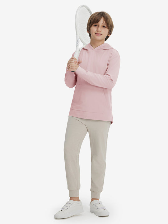 Model holding tennis racquet, wearing youth long sleeve hoodied with kangaroo pocket in light pink, full-body.