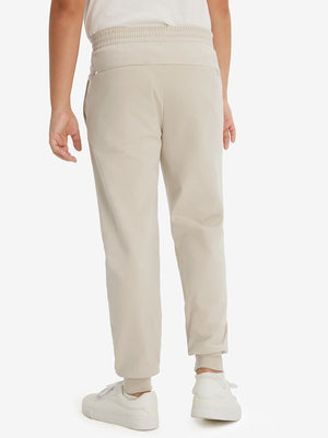 Model's lower body from the back, wearing light khaki fleece stretch water resistant boys joggers.
