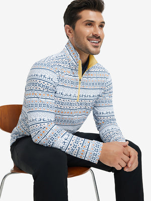 Model seated on chair, wearing full print quarter zip pullover in christmas snowflake, casual upper body view.