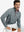 Model seated on chair, wearing full print quarter zip pullover in grey/wine camo, casual upper body view.