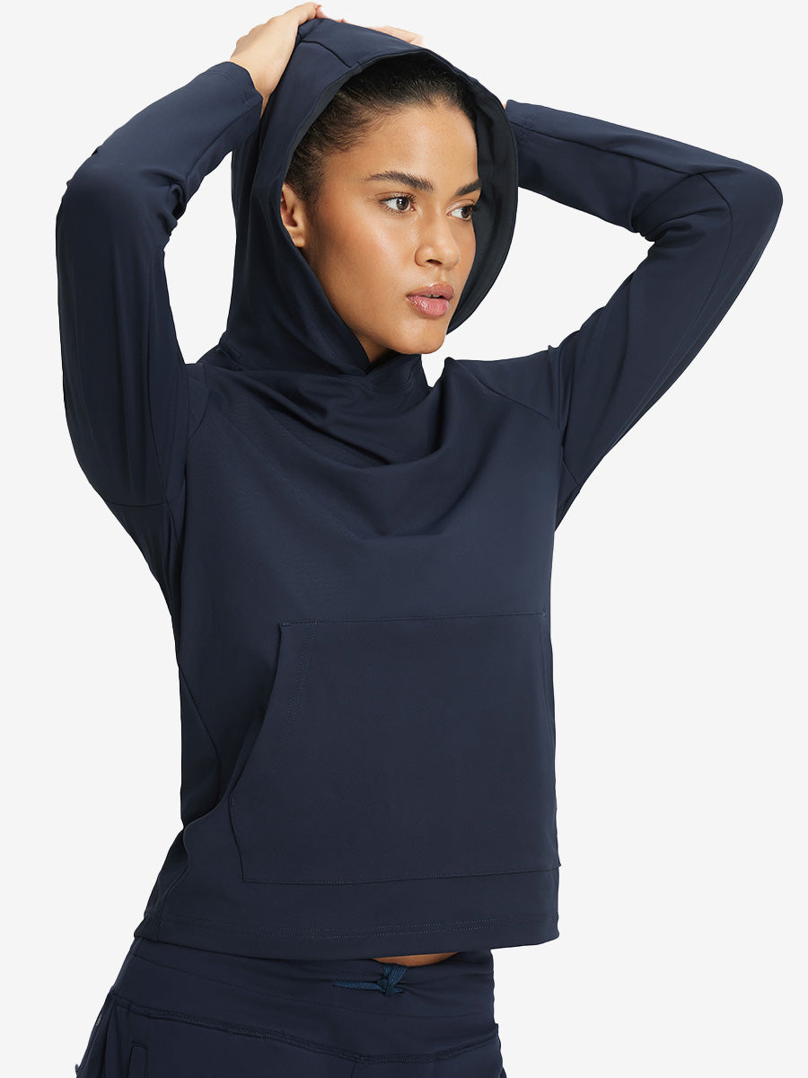 Model holding hoodie cap with both hands, wearing women's lightweight hoodies pullover in navy.