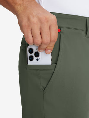 Hand placing an iPhone into pocket of soft lightweight casual golf pants with 5 pockets in olive green.