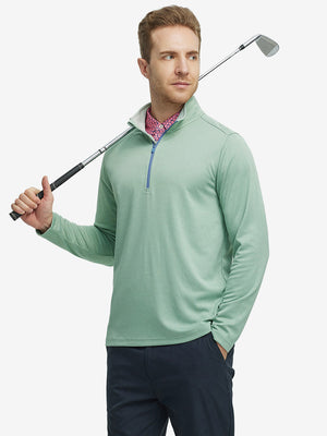 Full-body shot of model holding a golf club in beryl green melange moisture wicking quarter zip pullover