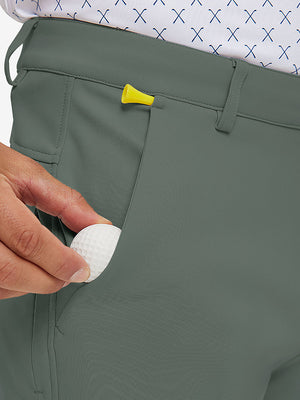 Hand placing a phone into front pocket of lightweight moisture wicking dress pants in slate green.