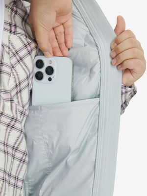 Close-up of boys full-zip fleece-lined puffer vest pocket holding a phone, practical detail in light grey