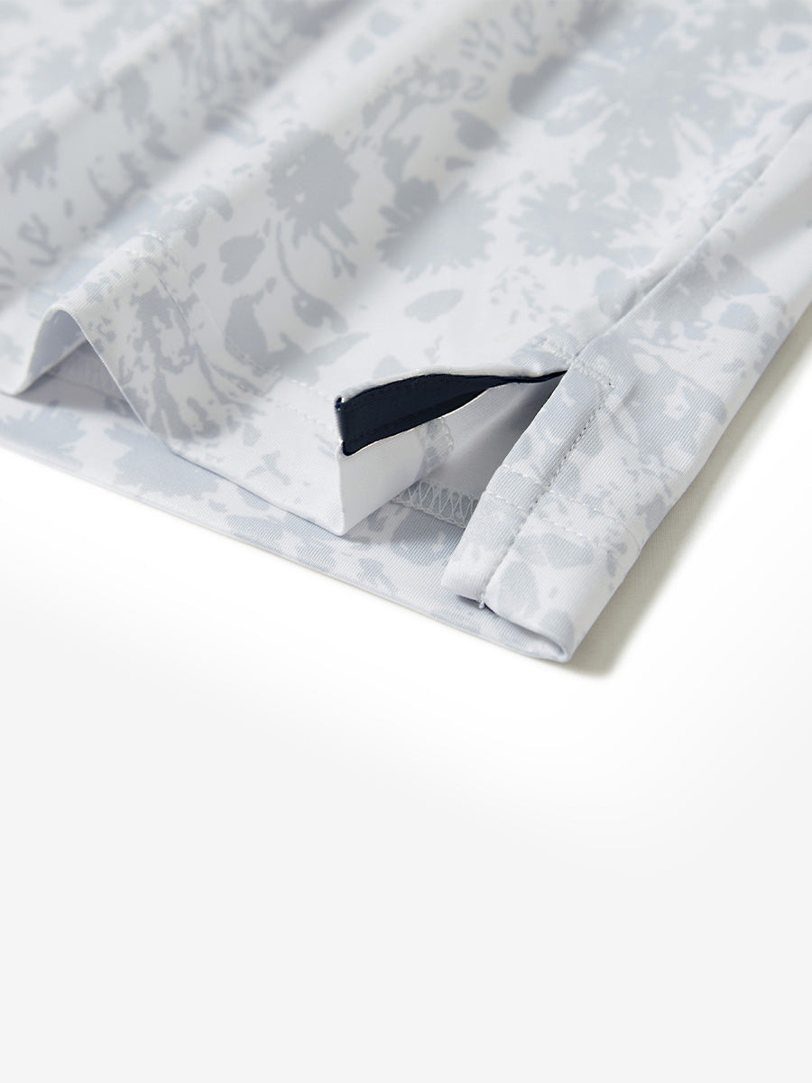 Hem slit detail of the gray ink splash lightweight print long sleeve polo, showing fine stitching and finish.