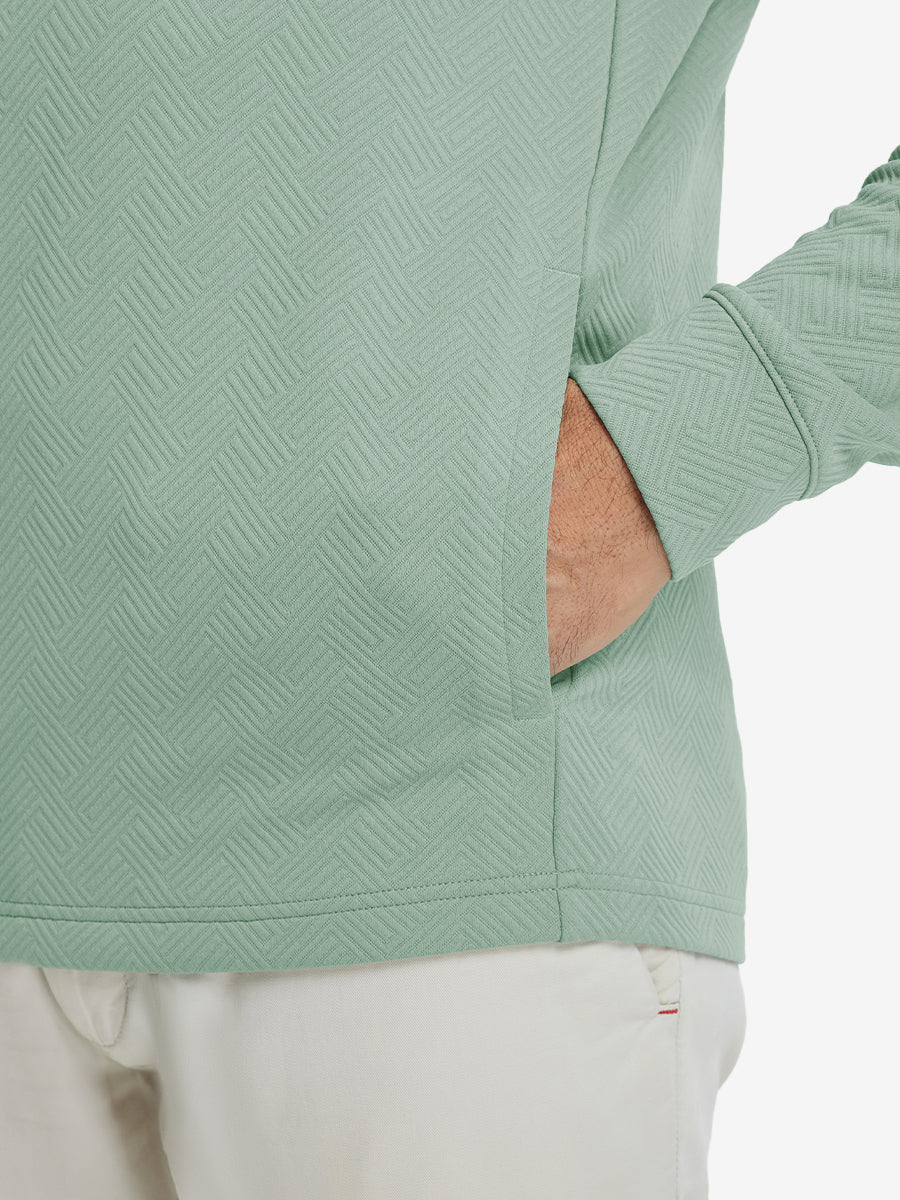 Close-up of pocket detail, single hand inside texture solid hoodies pullover, casual style in beryl green.