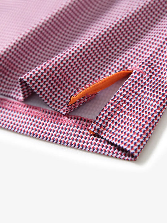MAELREG's hem slit detail showcases the RED PUZZLE BLOCK Polo shirt. Its refined craftsmanship and fabric texture highlight its high quality