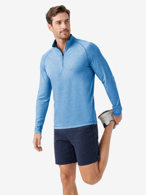  Full body model holding golf equipment for shooting, dry fit athletic 1/4 zip sweatshirt in blue heather