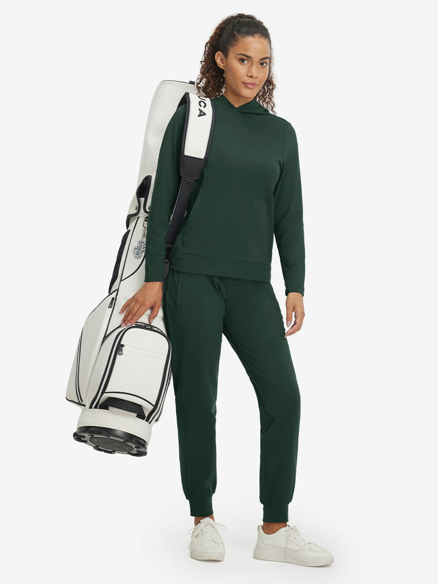 Model carrying golf bag, wearing women's lightweight hoodies pullover in forest green.