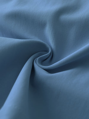 Close-up fabric detail of 4-way stretch performance solid shorts, smooth texture with flexible grayish blue feel