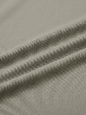Close-up of dark khaki ventilated pique performance polo fabric texture.