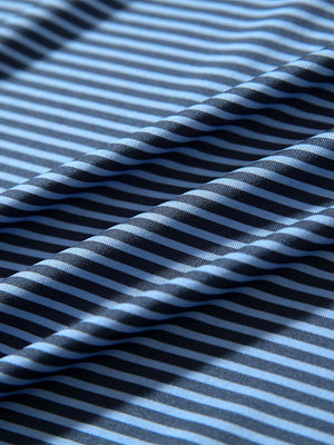 Close-up of blue denim stripe performance cooling polo - youth fabric texture.