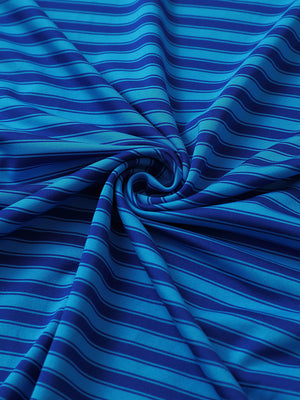 Close-up of dark blue yarn dyed stripe polo fabric showing distinct woven stripes and textured surface.