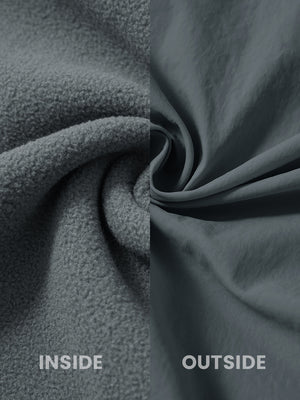 Close-up of the inside-out fabric of the reversible fleece jacket with 5 pockets in dark grey.