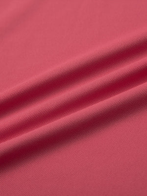 Close-up of brick ventilated pique performance polo fabric texture.