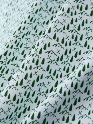 Macro view of the green forest 4 way stretch print collared polo shirt fabric, showcasing the unique print design