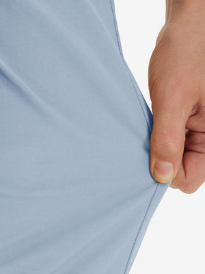 Action shot demonstrating the stretch of the sky blue youth water resistant cotton blend golf pants for active movement