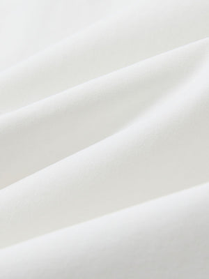Macro view of the white youth water resistant cotton blend golf pants fabric, showcasing the water repellent surface