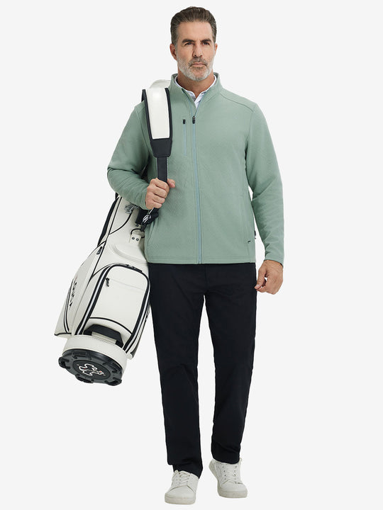 Full body shot, model carrying golf bag in textured insulated winter jacket, active outdoor style, beryl green.