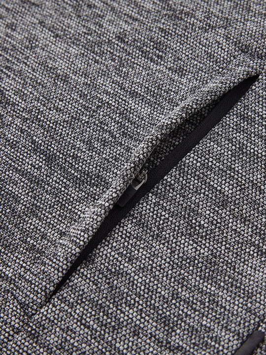 Close-up of jacket pocket showing fine stitching and insulation detail, textured insulated winter jacket, black heather.