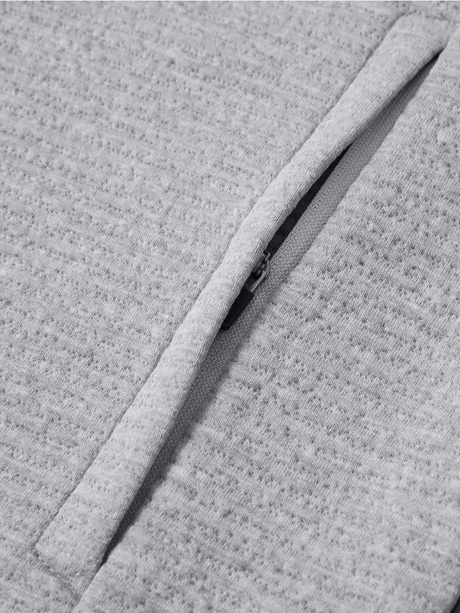 Close-up of jacket pocket showing fine stitching and insulation detail, textured insulated winter jacket, light grey heather.