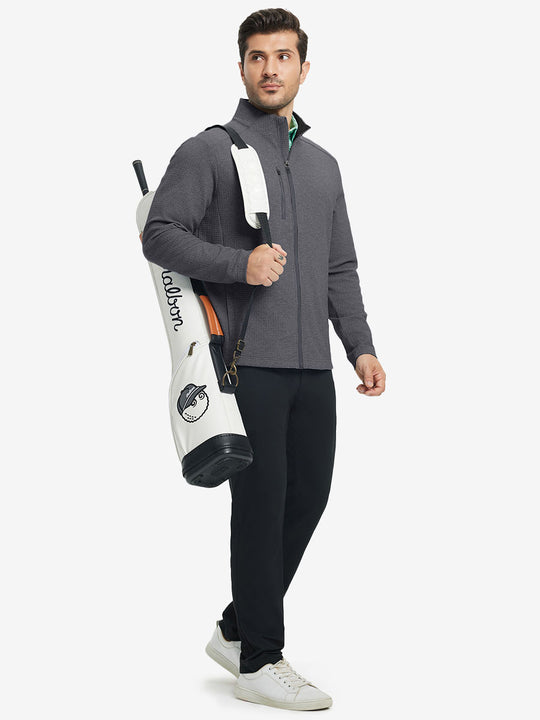 Full body shot, model carrying golf bag in textured insulated winter jacket, active outdoor style, grey heather.