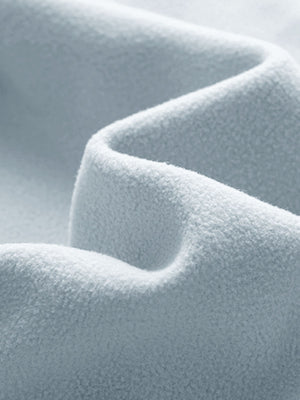 Close-up fabric detail of golf fleece winter puffer jackets, quilted texture and warm feel in glacier grey
